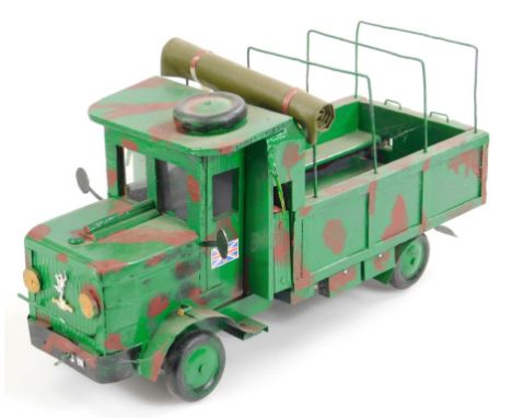 A 20thC wooden and metal model, of an army soldier delivery jeep, with articulated wheels in camouflage colours, 23cm high.