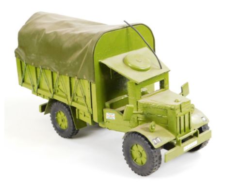 A 20thC wooden and metal model, of an army jeep, with shaped canvas back and articulated wheels, painted green, 29cm high.