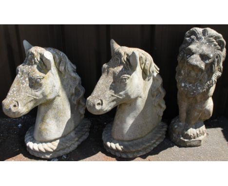 Two modern horse head stone gate finial ornaments, 50cm high, and another formed as a standing lion. (3)