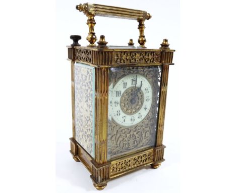 A late 19thC brass cased carriage clock, the rectangular dial with pierced and repoussé floral correction, enamel chapter rin