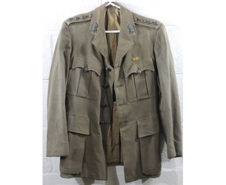 A mid 20thC army jacket, in green khaki with buttons to the shoulders and pockets, partially lined, probably WWII, size unkno