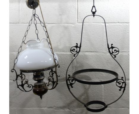An early 20thC cast metal angular light fitting, with milk glass shade 23cm high with metal mounts.