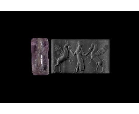 9th-6th century BC. An amethyst cylinder seal with bearded male between winged horses; accompanied by an old scholarly note, 