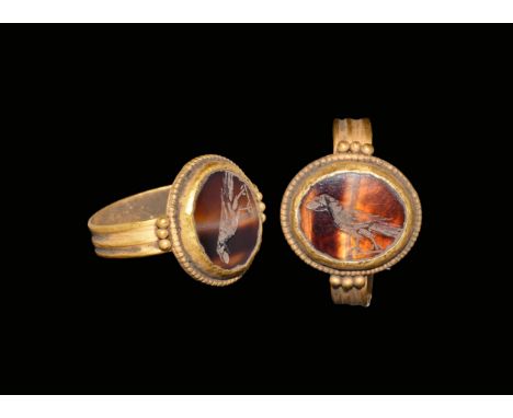 4th century AD. A ribbed gold hoop with three granules to each shoulder, discoid bezel with beaded wire rim, inset banded aga