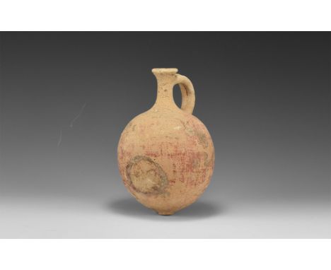 1st-3rd century AD. A globular terracotta flask with partial red slip surface, discoid base, slender neck with everted rim, b