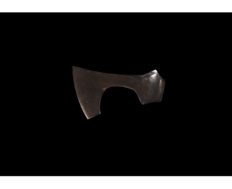 9th-11th century AD. A substantial iron axehead with gently curved blade and square chin, round socket with lateral wings abo