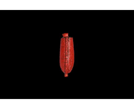 Amarna Period, 1353-1336 BC. A red glazed composition amuletic pendant of a domed palm leaf with median rib, loop to each end