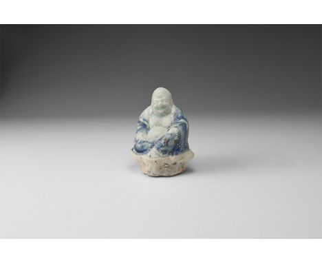 Qing Dynasty, 1644-1911 AD. A porcelain figure of the 'Laughing Buddha' (Putai) pale blue body with dark blue robes, seated o
