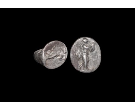 2nd-3rd century AD. A flat-section silver hop with expanding shoulders supporting a discoid plaque, high-relief image of Orph