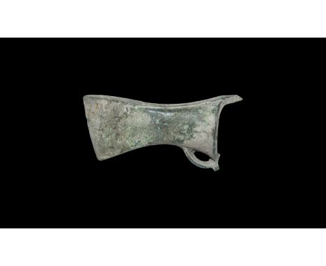 13th-9th century BC. A bronze axehead with scooped socket and flange to the mouth; the lozenge-section loop connected perpend