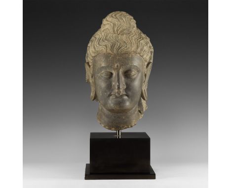 1st-4th century AD. A carved schist head of Buddha with wavy hair and top-knot, urna to the brow; mounted on a custom-made st