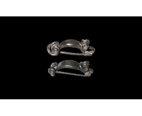 3rd-1st century BC. A pair of bronze brooches formed as a loop with collar and returned terminal with knop finial, coiled pin