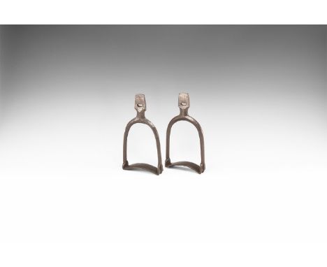 11th-12th century AD. A matched pair of iron stirrups, each a lozenge-section D-shaped frame with short neck and pierced trap