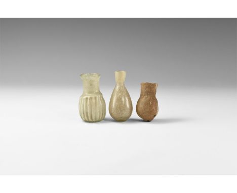 2nd-4th century AD. A mixed glass group comprising: a piriform jar with rounded base; a squat jar with knop to the base, roll