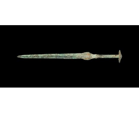 2nd millennium BC. A narrow bronze dagger with lentoid-section blade, crescentic lower guard, round-section grip with collars