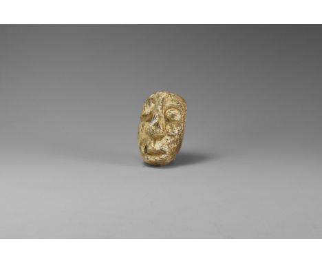 Pliocene Period, 5.2 - 2.5 million years BP. A Mastodon fossil tusk carved face from Java.   45 grams, 59mm (2 1/2"). From an