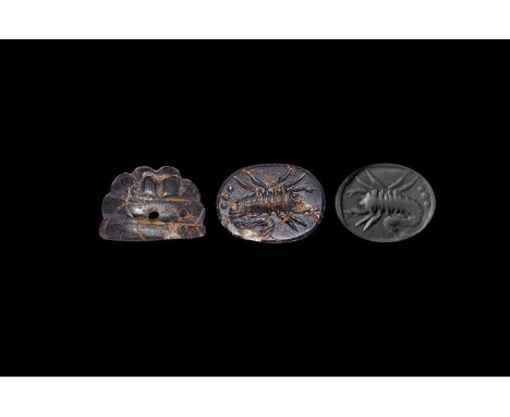 3rd-7th century AD. A haematite stamp seal, discoid in plan with domed upper face and ridged centre, intaglio crayfish or sco