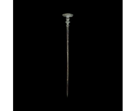 2nd millennium BC. A bronze tapering dress pin with hatched detail to the upper shank, three flange collars with beaded edges