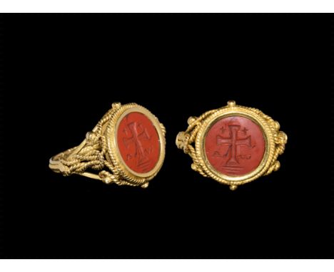 19th century AD. A red jasper discoid plaque with carved cross-on-steps motif, two smaller crosses above the arms, alpha and 