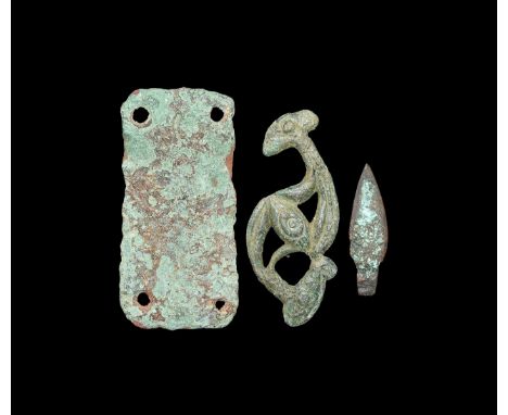 1st-3th century AD. A group of bronze items comprising of a flat openwork dragonesque plaque with irregular S-curved body, a 