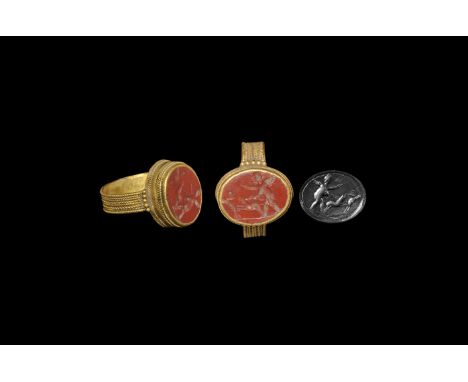 3rd-4th century AD. A flat-section gold hoop with filigree ropework exterior, granules to the shoulders, drum-shaped bezel wi