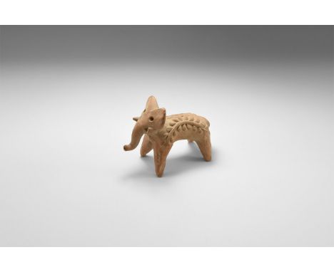 3rd-2nd millennium BC. A ceramic figure of an elephant with arching plant motif to the sides of the body.   227 grams, 11.4cm