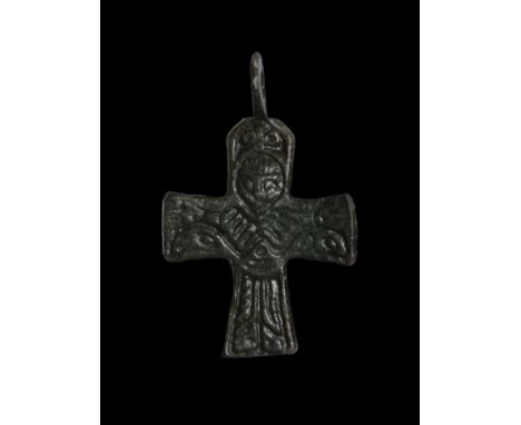 10th-11th century AD. A bronze cross with a standing Corpus Christi dressed in a long robe, cross above head, suspension ring