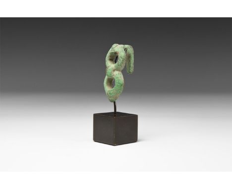 2nd century BC-1st century AD. A bronze fastener formed as two integral loops with comma-shaped bulbs to the centre and outer