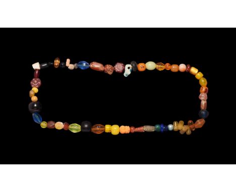 10th-20th century AD. A string of glass, stone and ceramic beads of barrel, oval, hexagon, irregular and other shapes.   44 g