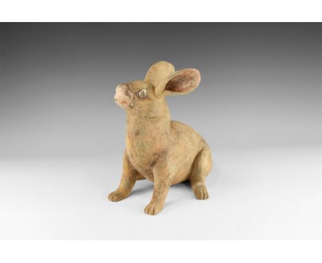 Tang Dynasty, 618-907 AD. A terracotta figurine of a rabbit modelled in the round standing upright on forepaws, ears pricked;