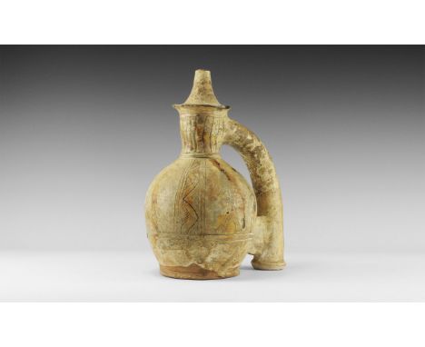 12th-13th century AD. A white-glazed ceramic vessel with bulbous body, flared base, barrel-shaped neck, flange and conical sp