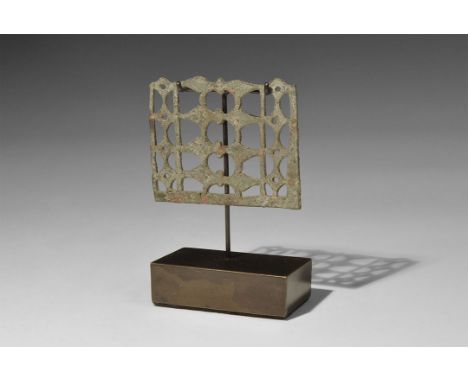 3rd-4th century AD. A rectangular plaque with openwork pattern of leaf- and lozenge-shaped panels, pierced for attachment; mo