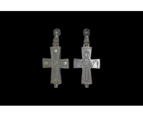 7th-9th century AD. A large bronze reliquary cross in two parts and held together by hinge and suspension loop; one side engr