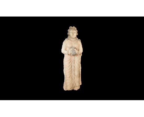7th-9th century AD or later. A very large ceramic statue of a standing female wearing a long folded robe holding a bundle of 