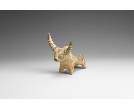 2nd millennium BC. A ceramic figurine of a zebu with exaggerated crescent horns, painted stripes to the horns and rump, trian