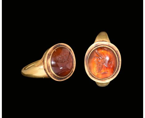 3rd century AD. A round-section gold hoop with facetted shoulders, discoid bezel with stepped inner cell, inset carnelian cab