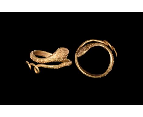Ptolemaic Period, 332-30 BC. A D-section coiled gold hoop with punched scale detailing, broad lozenge-shaped head with lentoi