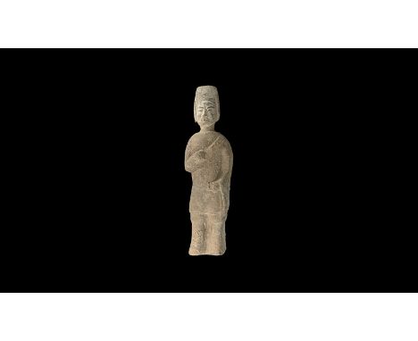Northern Qi Dynasty, 550-577 AD. A ceramic figure of a male wearing a cap with a tall peaked back, with flaps over the ears; 