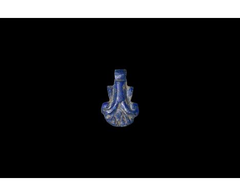 New Kingdom, 1550-1070 BC. A carved lapis lazuli bifacial amuletic pendant of a blossoming papyrus flower, pierced at the fin