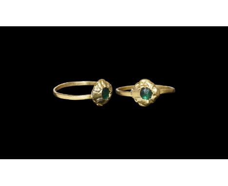 9th-12th century AD. A gold ring with slender hoop shank, flower-shaped bezel set with a green glass bead. Cf. Arbman, H. Bir