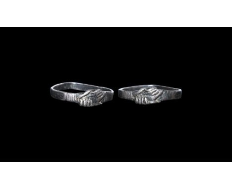 15th century AD. A flat-section silver ring with bezel formed as two clasped hands, ribbed cuff to the rear of each. Disclaim