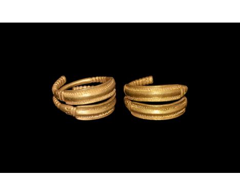 3rd century AD. A gold penannular ring formed as two curved plates each with midrib and lateral punched bands; to each end a 
