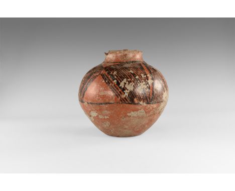 1st millennium BC. A globular red-glazed ceramic jar with waisted neck, band of black painted geometric ornament to the shoul