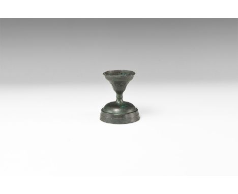 11th-13th century AD. A miniature chalice with tiered base, waisted stem and stepped bowl, raised rib detailing; beaded rim a
