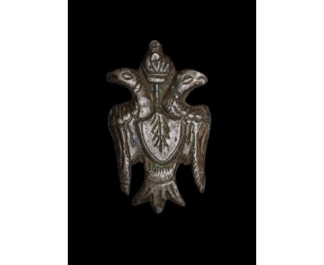 12th-13th century AD. A bronze mount in the form of a double-headed eagle with crest to the chest and crown above heads; ring