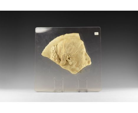 Early 1st century AD. A fine grained marble high relief panel with head of a female in profile, shield-shaped earring and hai