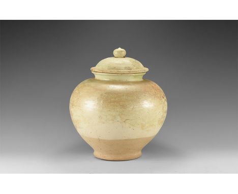 Tang Dynasty, 618-907 AD. A ceramic white ware jar with narrow base, globular body and low neck with rolled rim, separate lid