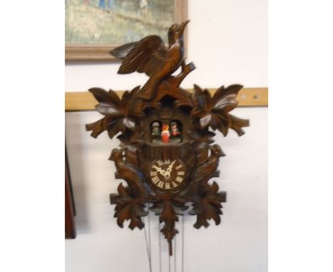 Black forest style cuckoo clock with cuckoo and people appearing on chime