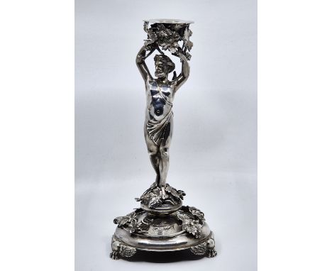 A Victorian silver candlestick,&nbsp;by S Smith &amp; Son, London 1880, modelled as a standing figure Bacchus holding an urn 