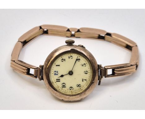 A 9ct. rose gold ladies' wrist watch, manual movement, having white enamel circular Arabic numeral dial with gold minute mark